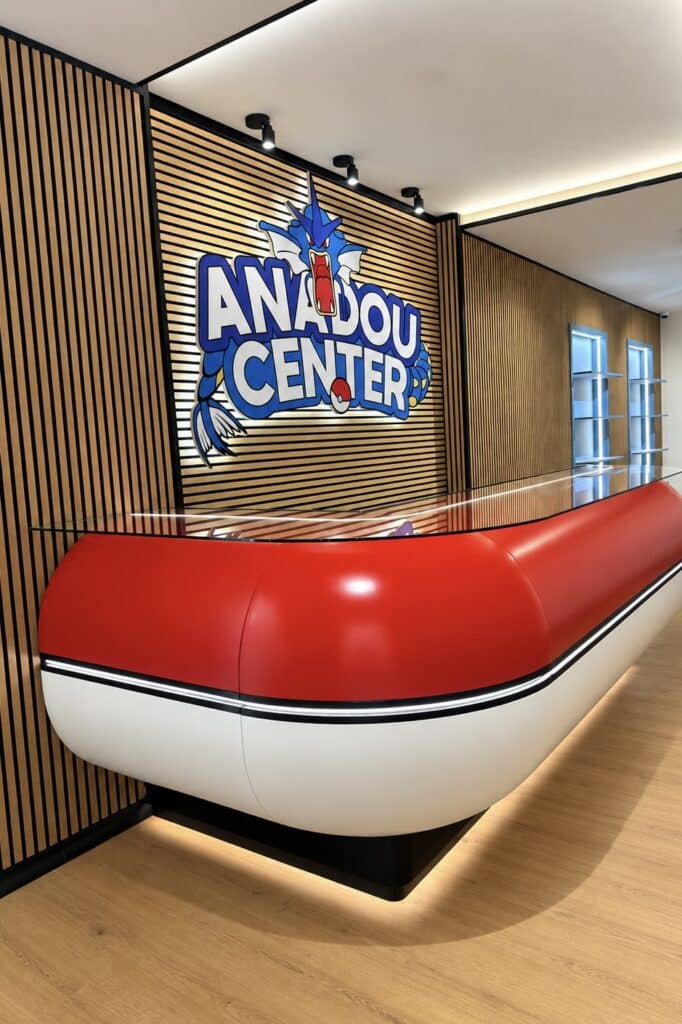 Comptoir Pokéball Anadou Center avec logo Gyarados sur mur en lattes de bois, design moderne et éclairé.