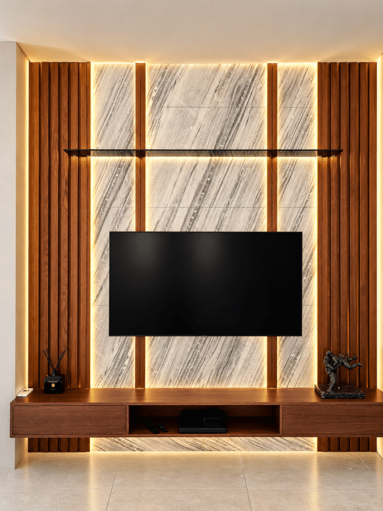 Mur TV moderne avec tasseaux de bois, panneaux de marbre rétroéclairés par LED et console suspendue en bois noble.